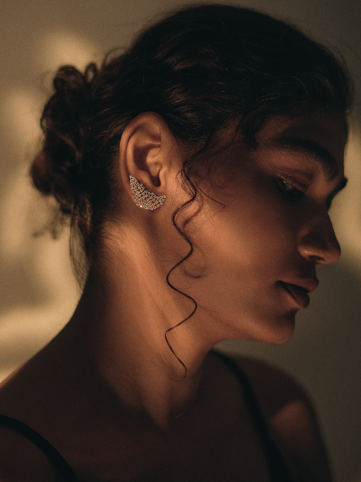 Close-up of a woman wearing a diamond earring with a blurred background